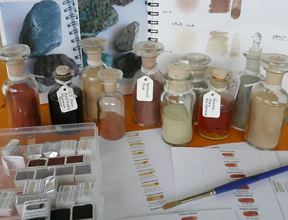 Bottles of pigment and workbook pages