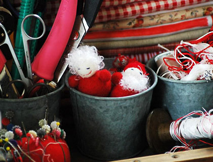 Folded fabric, spools of threads and tins of scissors in Mel's Natale studio.