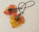 Ladybirds In Autumn: flame-coloured leaf earrings with green ladybugs