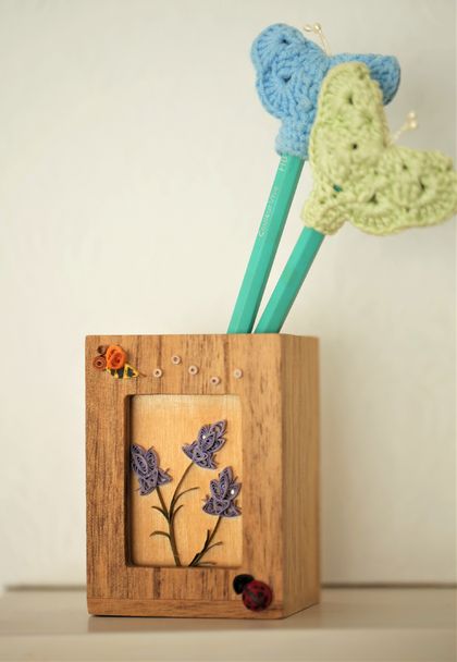 Wooden pen stand with paper quilling and crochet butterfly pen lids.