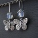 Moths In Moonlight earrings: silver moth charms with moonstone beads on silver ear-wires