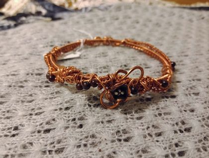 Elaborate wire wrapped copper bangle with garnet