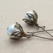 White Buds earrings: glass pearls with leafy bronze caps on long ear-wires
