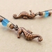 Burnished Ocean earrings: antiqued-copper seahorses with coconut shell and blue glass