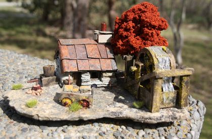 Miniature Model Stone Mining Cottage with water tank, water wheel with artificial water, gold cart with stone and artificial gold and brown tree.